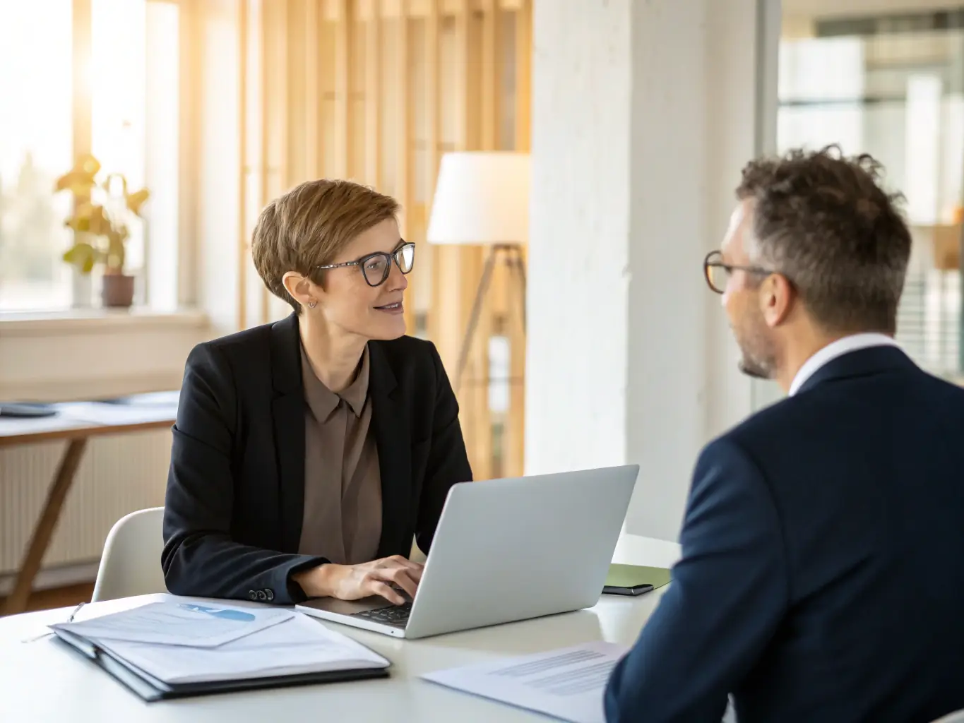 A professional business coach is working with a client in a modern office, reviewing business growth charts and discussing strategies for improvement. The scene conveys trust, expertise, and a collaborative approach to business development.